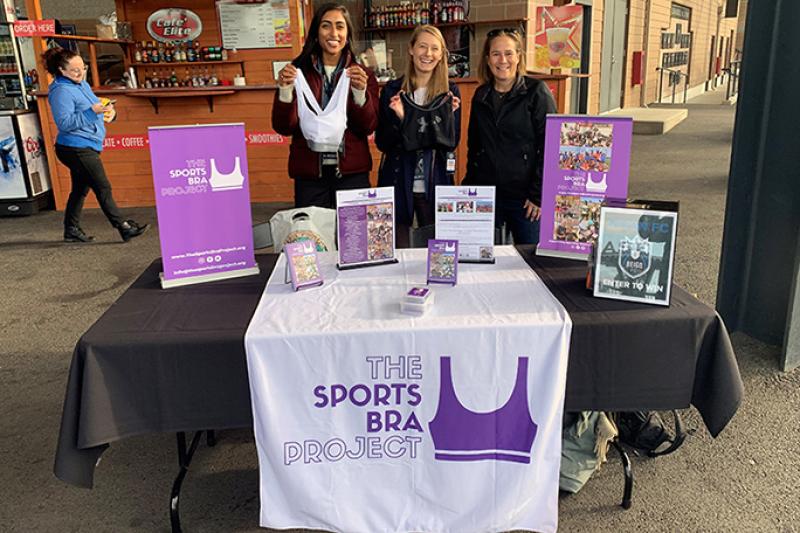 Members of The Sports Bra Project at holding up a bra at a drive.